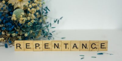 a wooden block that says repentance next to a bouquet of flowers